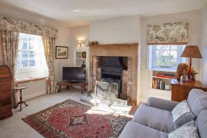 sala de estar con sofá y chimenea en Host & Stay - Tithe Cottage en Harrogate