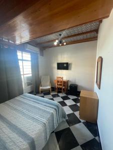 um quarto com uma cama e um piso em xadrez em El Ancla em Alcalá del Río