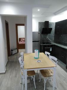 une cuisine avec une table et des chaises ainsi qu'un gâteau. dans l'établissement Résidence Inès Djerba Appartement de Luxe, à Houmt Souk