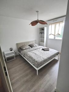 1 dormitorio con 1 cama y ventilador de techo en Capbreton Superbe appartement avec parking en Capbreton