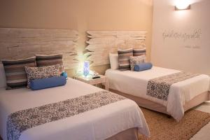 a bedroom with two beds and a stone wall at H2Otel By LD Hotel Boutique in La Mira