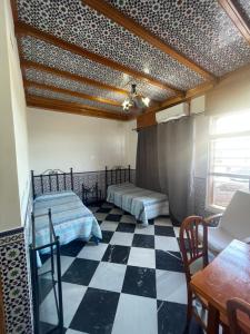 a room with two beds and a checkered floor at El Ancla in Alcalá del Río
