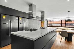 a kitchen with black cabinets and a white counter top at Build it in Bogotá - Premium Coliving in Bogotá