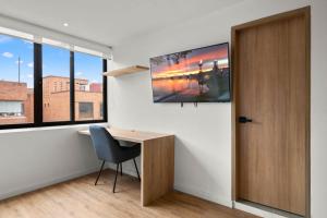 a room with a desk and a tv on a wall at Build it in Bogotá - Premium Coliving in Bogotá