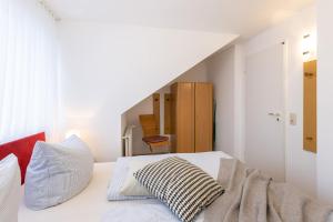 een slaapkamer met een wit bed en een trap bij M3 - Apartmenthaus Marienburger Str 4 - FERIENDOMIZIL HOLLICH in Grömitz