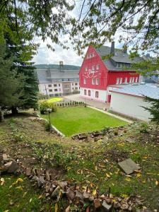 un grande edificio rosso con un prato verde davanti di Haus ZUR PINGE a Kurort Altenberg
