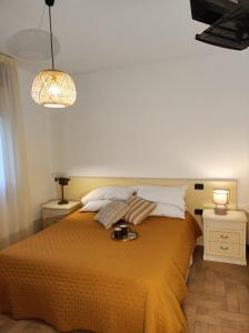 a bedroom with a bed with a yellow blanket and two night stands at Borgo di Arcadia in Porto Tolle