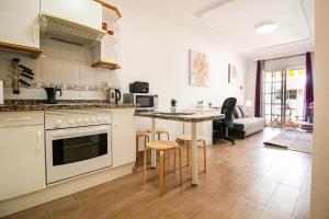 a kitchen and living room with a counter and a table at Beautiful Apartment by the Sea in Playa San Juan in Playa de San Juan
