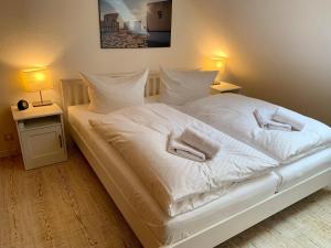 a bedroom with a white bed with two towels on it at Ferienwohnung "Laura" in Sankt Peter-Ording