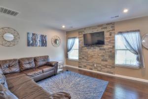 uma sala de estar com um sofá de couro e uma parede de pedra em The Muirwood Retreat em Murfreesboro