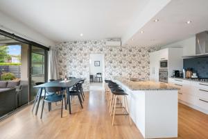 a kitchen and living room with a table and chairs at Urban Oasis - Wanaka Holiday Home in Wanaka