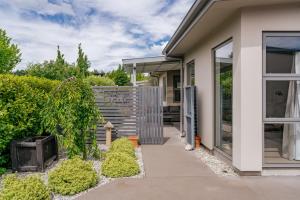 a house with a walkway leading into a yard at Urban Oasis - Wanaka Holiday Home in Wanaka