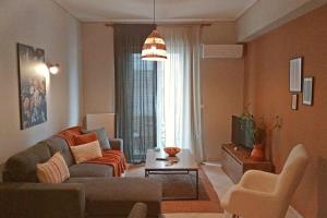 sala de estar con sofá y TV en Central Artistic 2-Bedroom Apartment 79sqm, en Tripolis