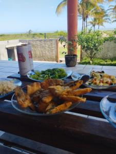 uma mesa com três pratos de comida em Casa frente para o mar em Nova Viçosa