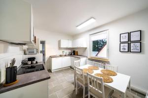 a kitchen with a table and chairs in a kitchen at Modernisiertes Altbau 3-Zi Apartment in Rinteln
