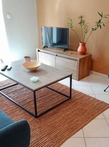sala de estar con mesa y TV en Central Artistic 2-Bedroom Apartment 79sqm en Tripolis