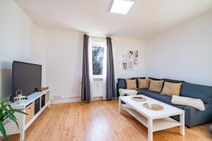 sala de estar con sofá azul y TV en Modernisiertes Altbau 3-Zi Apartment, en Rinteln