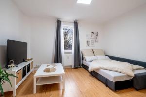 ein Wohnzimmer mit einem Sofa und einem TV in der Unterkunft Modernisiertes Altbau 3-Zi Apartment in Rinteln