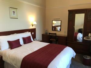 a hotel room with a large bed and a mirror at The Bowden Lodge in Southport