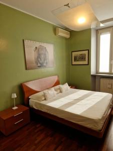 a bedroom with a large bed with green walls at Cozy flat mins walk to Navigli and metro Porta Genova in Milan