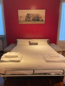 Ce lit se trouve dans une chambre dotée d'un mur rouge. dans l'établissement Cozy flat mins walk to Navigli and metro Porta Genova, à Milan