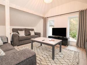 a living room with a couch and a table at The Lodge at Bridgeway in Whalley