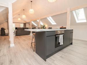a kitchen with a large island in a living room at The Lodge at Bridgeway in Whalley