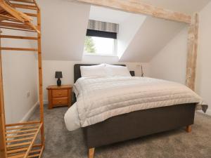 1 dormitorio con cama y escalera de madera en The Lodge at Bridgeway en Whalley