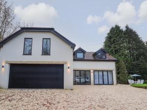 a white house with a garage at The Lodge at Bridgeway in Whalley