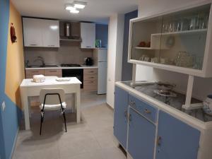 a kitchen with a table and a stool in it at Casa RoSa in Acitrezza