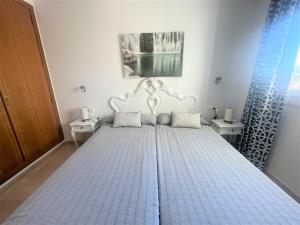 1 dormitorio con 1 cama con marco blanco en Gemelos 22-2-24, en Benidorm