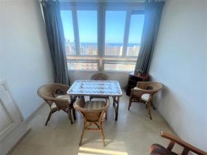 mesa y sillas en una habitación con ventana en Gemelos 22-2-24, en Benidorm