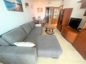 sala de estar con sofá azul y mesa en Gemelos 22-2-24, en Benidorm