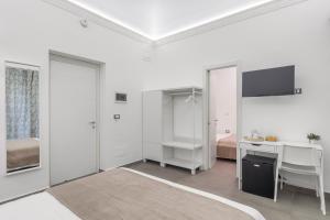 um quarto branco com uma secretária e uma cama em MolteVolte Rooms em Palermo