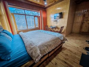 a bedroom with a large bed and a window at The Alpinist cafe and Retreat in Kaza