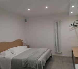 a white bedroom with a bed and a radiator at President House Matera in Matera