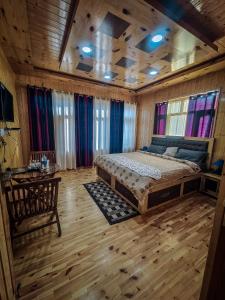 a bedroom with a large bed in a room with wooden floors at The Alpinist cafe and Retreat in Kaza