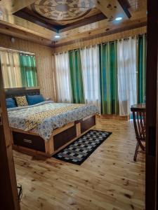 a bedroom with a bed in a room with wooden floors at The Alpinist cafe and Retreat in Kaza