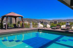 a swimming pool with chairs and a gazebo at Ecohotel Talca in Talca +36 photos