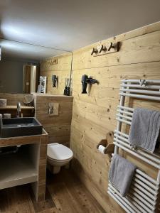 ein Holzbadezimmer mit einem Waschbecken und einem WC in der Unterkunft Chalet de l'Ours : 4 étoiles-spa-proche des pistes in La Clusaz