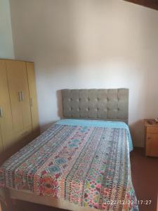 1 dormitorio con 1 cama con edredón en Departamento CatyDay en Mina Clavero
