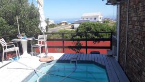 a small swimming pool on a balcony with a table and chairs at TOEVLUG in Gansbaai