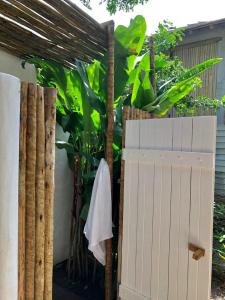 een hek met een witte deur en een aantal planten bij Suítes Casa Kamayurá in Trancoso
