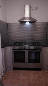 a kitchen with a stove and a hood at Reach Guest House in Birmingham