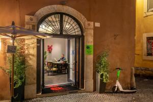 un hombre sentado en una mesa en una puerta abierta en Navona Colors Hotel en Roma