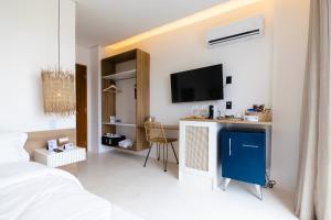 1 dormitorio con 1 cama y TV en la pared en Mikiki Lifestyle Hotel en Barra Grande