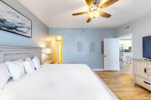 a bedroom with a bed and a ceiling fan at Shores of Panama 1517 in Panama City Beach +10 photos