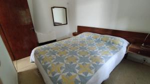 a bedroom with a bed with a blue and yellow quilt at Casa en Playa Verde a media cuadra del mar in Playa Verde