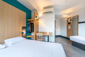 um quarto com uma cama branca e uma secretária em B&B HOTEL Cholet Sud em Cholet