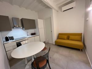 a kitchen with a white table and a yellow couch at CasaDea in Cremona
